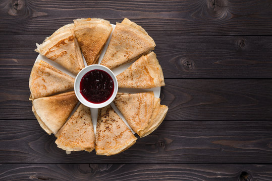 pancakes with jam on a wooden background
