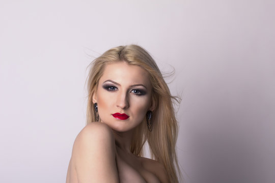 Pretty blonde woman face over a grey background