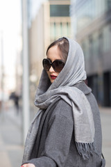 Attractive brunette in grey shawl outdoors, springtime