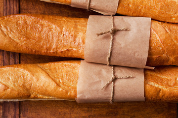 Freshly baked French baguettes on dark wooden table, close-up