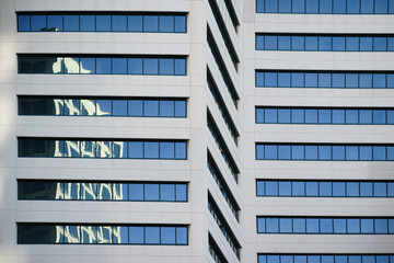 Abstrakte Reflektionen am Hochhaus / Abstrakte Reflektionen von umliegenden Gebäuden in den Fenstern eines modernen Hochhauses.