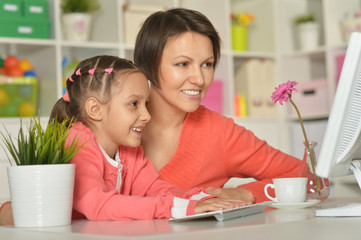 little girl  with mother and computer