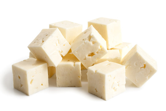 Square cubes of feta cheese isolated on white.