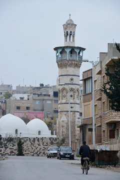 Man on the bicycle is moving to minaret in Hama