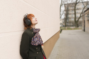 Kobieta słucha muzyki przez słuchawki. - obrazy, fototapety, plakaty