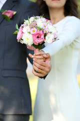 Obraz na płótnie Canvas Bride and groom holding wedding bouquet