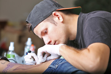 Tattooist makes tattoo, close up