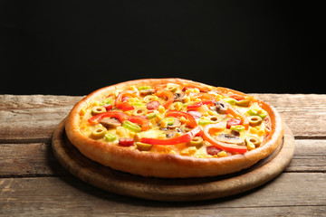 Delicious pizza with vegetables on black background