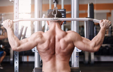 muscular body building men training his back at the gym