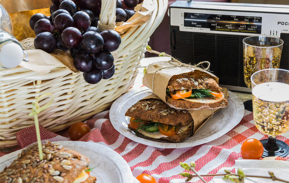 Delicious savory salad sandwiches served on a red and white checked tablecloth for a healthy outdoors summer picnic