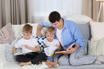 Family concept. father with sons together reading books in the room