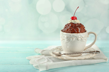 Chocolate mug cake with cream and cherry on a table