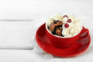 Chocolate mug cake with cream and cranberry on a white napkin