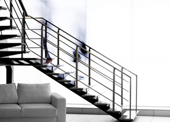 Modern stairs in office and blurred silhouettes of moving people