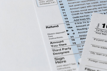Part of the 1040 Individual Income Tax Return Form for 2015 year on the white wooden desk, close up