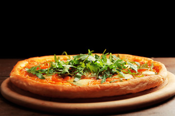 Margherita pizza with arugula on wooden table