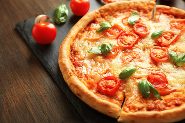 Margherita pizza with tomatoes on slate plate