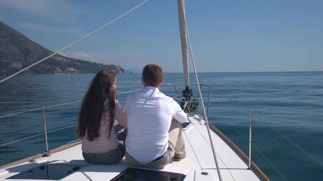 enamored couple sitting on a yacht