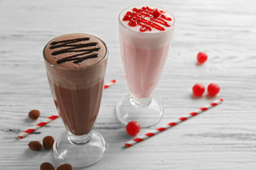 Fototapeta na wymiar Glasses of chocolate milkshake on wooden background