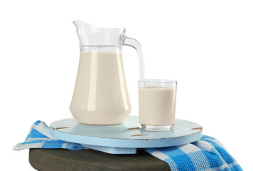 Glass of milk with napkin on wooden stool isolated on white