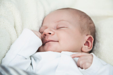Smiling newborn baby boy asleep