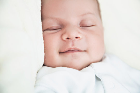 Smiling newborn baby asleep
