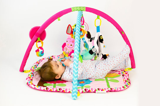 baby girl playing in an activity gym
