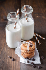 Milk bottles and chocolate chips cookies. Toned image. Selective focus