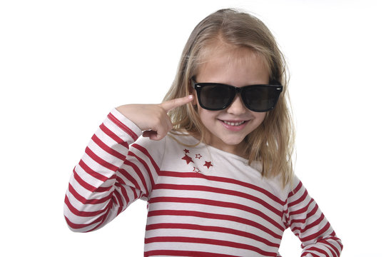 beautiful 6 to 8 years old female child with blond hair wearing big sunglasses smiling happy and playful