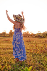 Happy, free, young woman dances in a field of sunshine