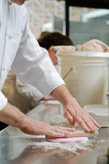 Pastry chef works with fondant for cake decorating