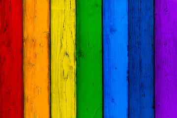Natural wooden rainbow colored boards. Painted wooden multicolored vertical planks. Abstract textured many-colored background, empty template. Red, orange, yellow, green, blue, violet planks of wood