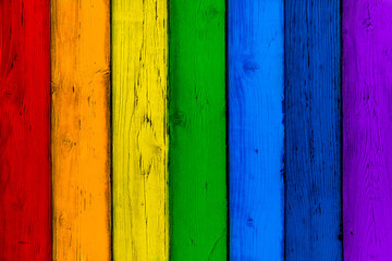 Natural wooden rainbow colored boards. Painted wooden multicolored vertical planks. Abstract textured many-colored background, empty template. Red, orange, yellow, green, blue, violet planks of wood