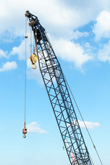 Crane with hook in sky background
