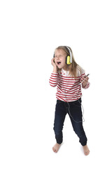sweet little girl with blonde hair listening to music with headphones and mobile phone singing and dancing happy