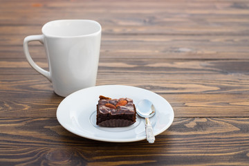 Homemade chocolate brownie with almond and a white mug cup