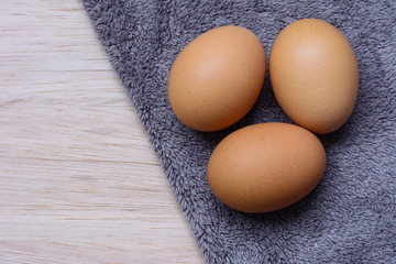 Fresh eggs on wooden and Microfiber Cloth background