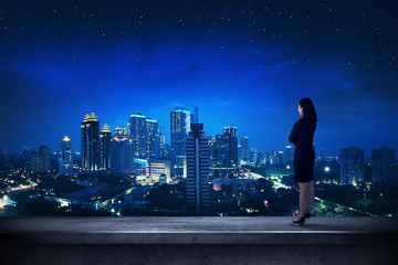 Fototapeta premium Asian business person standing on the rooftop