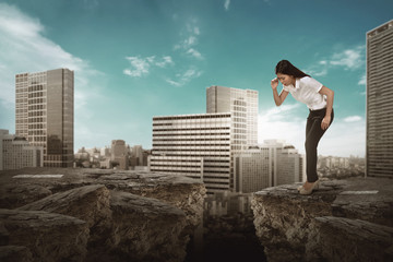 Business woman looking down on broken road