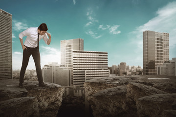 Business man looking down on broken road