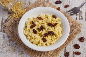 Cooked millet groats on white plate, healthy food and nutrition