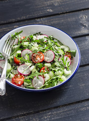 Fresh salad with couscous, tomatoes, cucumber, radish and arugula. Healthy vegetarian food