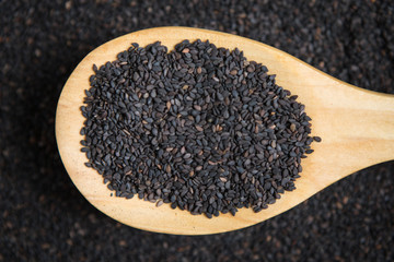 scoop of black sesame on a blurry pile of black sesame. Selectiv