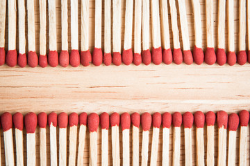 pile of match arrange in a row on a wood background.