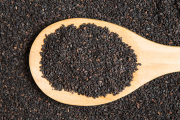 scoop of black sesame on a pile of black sesame