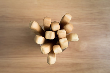 Fototapeta na wymiar Top view of a cup of bread stick on a wooden background.