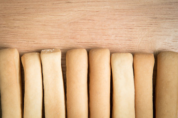 row of  bread stick arrange on a wooden background.