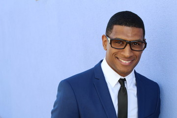 Handsome smiling confident African businessman portrait with copy space on the left