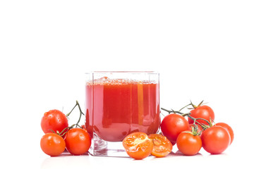 full glass of tomato juice with a bunch of tomatoes