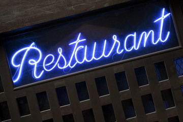 Fototapeta premium Neon blue illuminated lit up restaurant sign at night photo